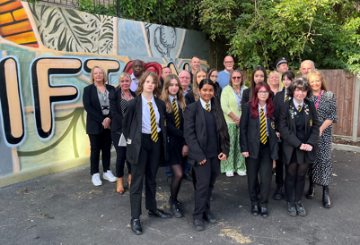 Children from Farnborough Academy and local councillors, artist and stakeholders in front of Kieron Hill mural in Clifton